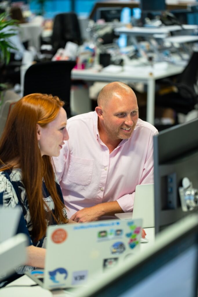 man in pink button up shirt sitting beside woman in blue and black shirt